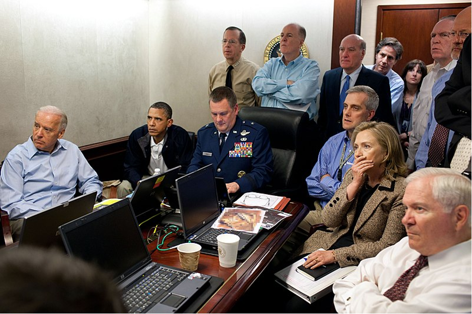 President Obama and members of his national security team receive an update on Operation Neptune Spear, a mission against Osama bin Laden, in one of the conference rooms of the Situation Room of the White House. They are watching live feed from drones operating over the bin Laden complex. (Photographed by Pete Souza)